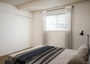 Thumbnail 7 of 26 - A bedroom with a bed, pillows, and a window with curtains.
