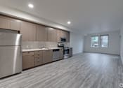Thumbnail 58 of 59 - A modern kitchen with wooden floors and stainless steel appliances.