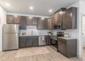 Thumbnail 1 of 46 - a kitchen with stainless steel appliances and wooden cabinets