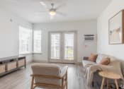 Thumbnail 4 of 46 - a living room with a couch and a chair and a ceiling fan
