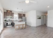 Thumbnail 3 of 46 - a living room with a kitchen and a ceiling fan