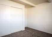 Thumbnail 8 of 26 - A room with a white wall and a brown carpet.