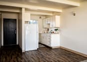 Thumbnail 4 of 26 - A kitchen with white appliances and wooden floors.