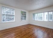Thumbnail 35 of 52 - A room with wooden floors and three windows.