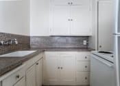 Thumbnail 39 of 52 - A kitchen with white cabinets and a granite countertop.