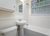 Thumbnail 38 of 52 - A white bathroom with a sink, toilet and bathtub.