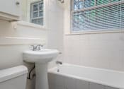 Thumbnail 36 of 52 - A white sink is in a white bathroom with a white tub.