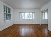 Thumbnail 37 of 52 - A room with wooden floors and three windows.