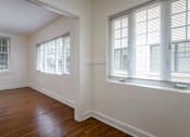 Thumbnail 41 of 52 - A room with wooden floors and two windows with blinds.