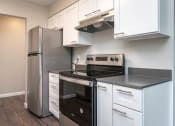 Thumbnail 10 of 27 - Vantage at Hillsdale | #3 Kitchen with White Cabinetry and Black & Stainless Steel Appliances