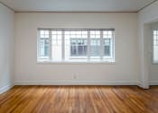 Thumbnail 26 of 52 - A room with a large window and wooden floors.