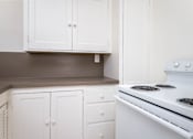 Thumbnail 25 of 52 - A white stove with two burners is in a kitchen with white cabinets.