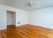 Thumbnail 23 of 52 - A room with a wooden floor and a ceiling fan.