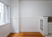 Thumbnail 28 of 52 - A kitchen with white cabinets and a wooden floor.