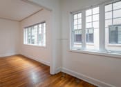 Thumbnail 24 of 52 - A room with wooden floors and three windows.