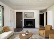 Thumbnail 3 of 24 - a living room with a fireplace and a couch and a coffee table