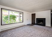 Thumbnail 17 of 24 - an empty living room with a fireplace and a large window