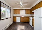 Thumbnail 14 of 24 - an empty kitchen with white appliances and wooden cabinets
