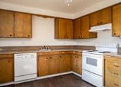Thumbnail 13 of 24 - an empty kitchen with white appliances and wooden cabinets