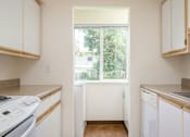 Thumbnail 15 of 26 - A kitchen with white appliances and cabinets.