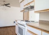 Thumbnail 16 of 26 - A modern kitchen with a stove top oven and a fan.