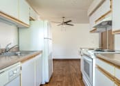 Thumbnail 13 of 26 - A kitchen with white appliances and wooden cabinets.
