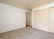 Thumbnail 11 of 26 - A room with a carpeted floor and a doorway leading to another room.