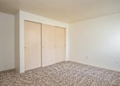 Thumbnail 10 of 26 - A room with two doors and carpeted floor.