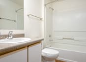 Thumbnail 17 of 26 - A white toilet sits next to a sink in a bathroom.