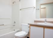 Thumbnail 24 of 26 - A white toilet sits next to a bathtub in a bathroom.