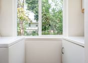 Thumbnail 26 of 26 - A white sink in a bathroom with a window overlooking a green area.