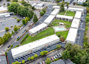 Thumbnail 26 of 26 - A parking lot with cars and a building in the background.