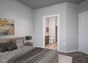 Thumbnail 8 of 13 - A bedroom with a bed, nightstand, and a painting on the wall.