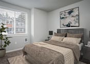 Thumbnail 12 of 13 - A bedroom with a large bed and a potted plant.