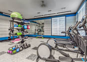Thumbnail 5 of 11 - A gym with a row of treadmills and exercise equipment at Crabtree Lakeside Apartments, Raleigh