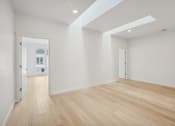 Thumbnail 24 of 45 - a living room with white walls and wooden floors