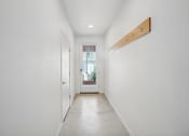 Thumbnail 29 of 45 - a long hallway with white walls and a white door to a house