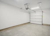Thumbnail 39 of 45 - a empty garage with a white wall and a garage door
