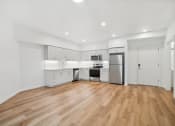 Thumbnail 33 of 45 - a white kitchen with a hard wood floor and a refrigerator