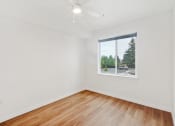 Thumbnail 40 of 45 - a living room with white walls and a window and wood floors