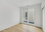 Thumbnail 41 of 45 - a living room with white walls and a large window with blinds