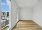 Thumbnail 34 of 45 - a living room with a large window and a wooden floor