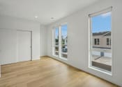 Thumbnail 31 of 45 - a living room with large windows and a door to a street