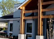 Thumbnail 2 of 45 - the front of the house is clad in metal siding and wood beams