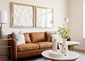 Thumbnail 18 of 36 - Leather sofa in natural lighting, side table with lamp, and small coffee table