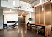 Thumbnail 21 of 36 - Lobby with large wooden table and seating for six. Polished concrete floor and marble fire place