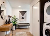Thumbnail 31 of 36 - Entry foyer with washer and dryer in a closet with small bench and table and mirror
