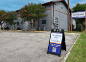 Thumbnail 1 of 20 - a sign in front of a building advertising car rentals at The Crossings at Montrose Apartments, San Antonio