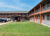 Thumbnail 18 of 20 - an exterior view of a building with a lawn and a parking lot at The Crossings at Montrose Apartments, Texas