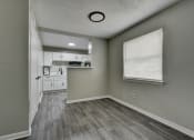 Thumbnail 9 of 20 - an empty room with a kitchen and a window at The Crossings at Montrose Apartments, San Antonio, TX, 78223